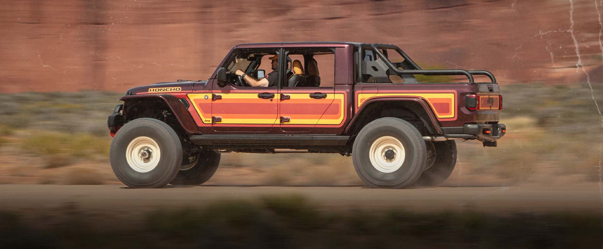 Vista lateral del lado del conductor de un vehículo conceptual Jeep Gladiator High Top Honcho 2025 en tonos de amarillo, naranja y rojo.