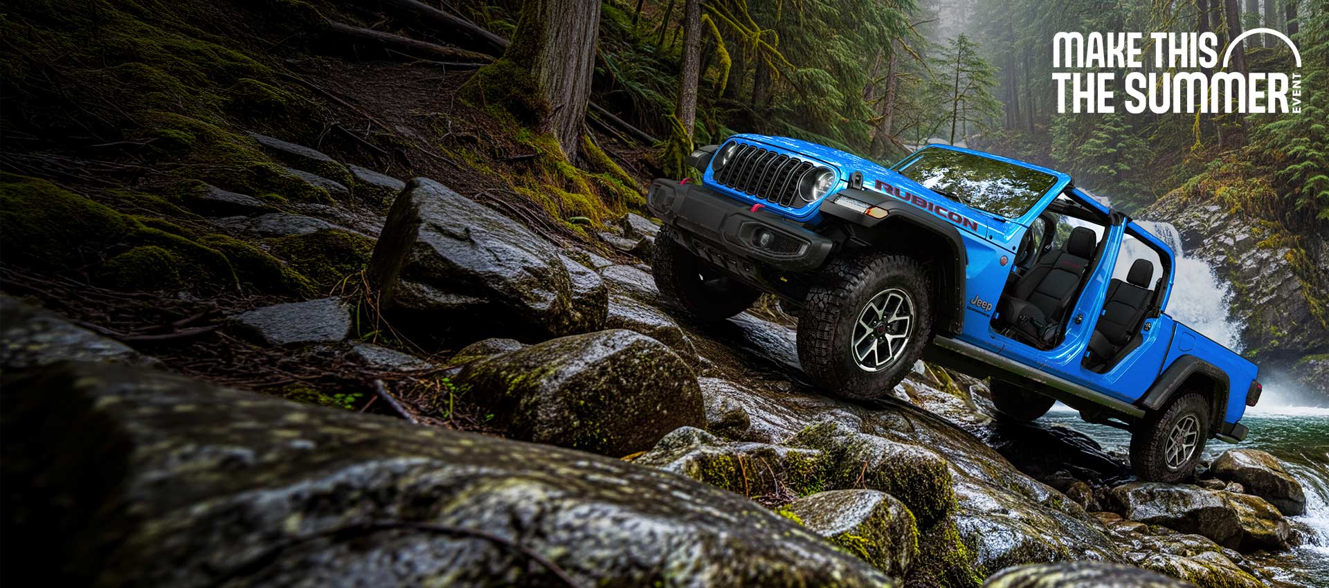 Un Jeep Gladiator Rubicon 2026 azul sin puertas ni techo, estacionado en un sendero empinado y rocoso, justo encima de un arroyo caudaloso con una cascada al fondo. Evento de ventas del 4 de julio.