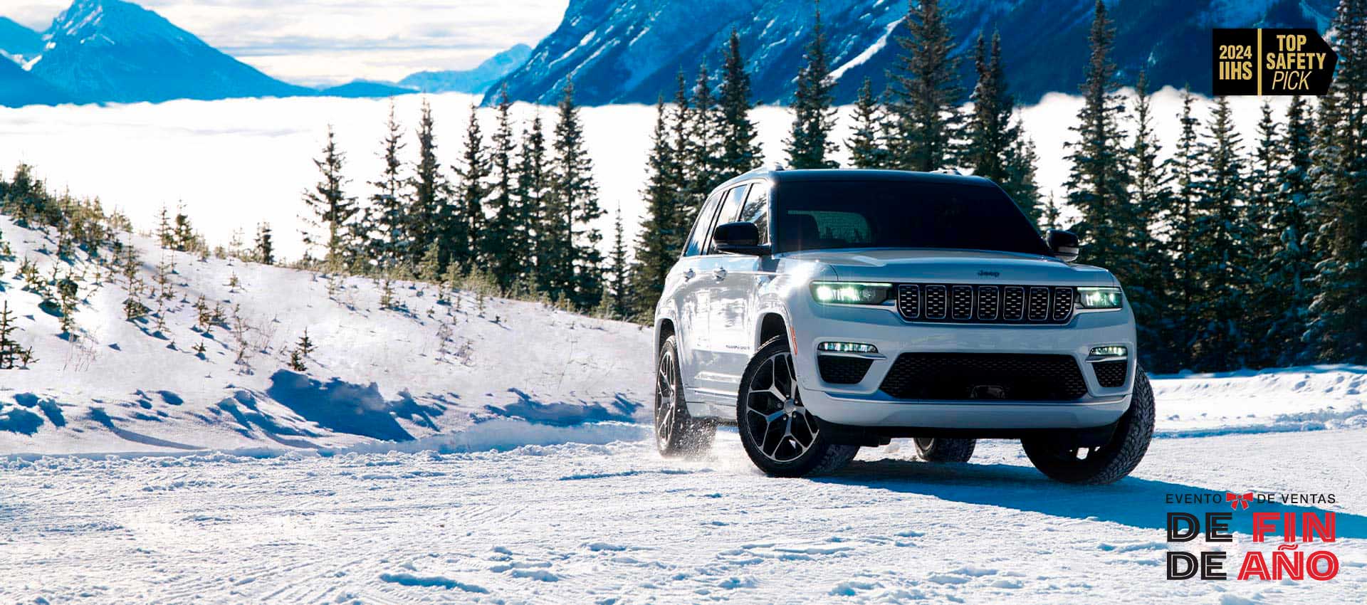 Un Jeep Grand Cherokee Summit Reserve 2024 blanco circulando por un camino cubierto de nieve en las montañas. Top Safety Pick de IIHS de 2024. Evento de ventas Fin de año.