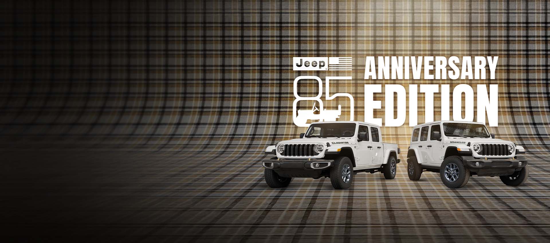 Un Jeep Gladiator 85th Anniversary Edition 2026 en blanco a la izquierda y un Jeep Wrangler 85th Anniversary Edition 2026 en blanco a la derecha, estacionados sobre una superficie a cuadros continua que se extiende por la pared del fondo. Jeep 85 Anniversary Edition.