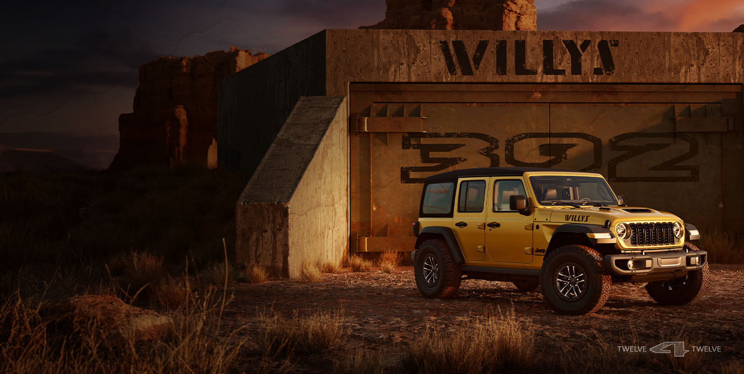A passenger-side front angle of a gold 2026 Jeep Wrangler Willys 392 parked in front of a fortress entrance in the desert, labelled Willys 392.